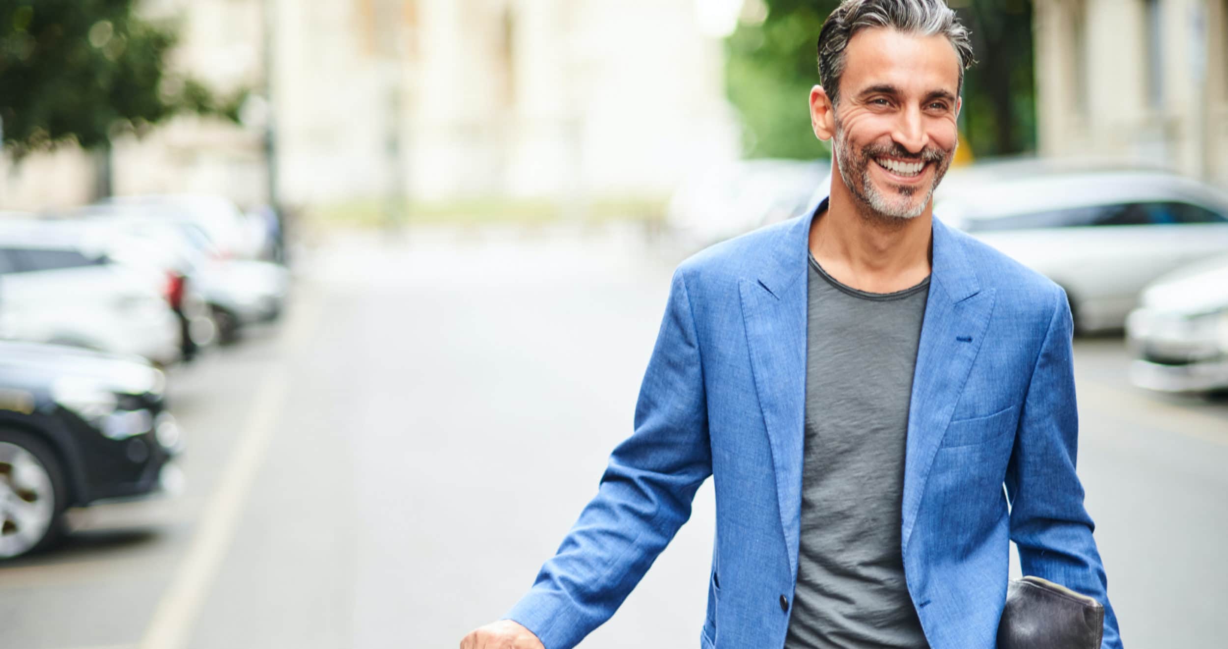 man in blue jacket walking in street