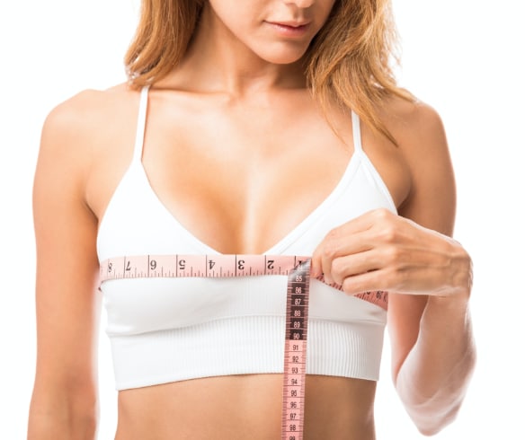 woman measuring chest with tape measure for Breast Reduction