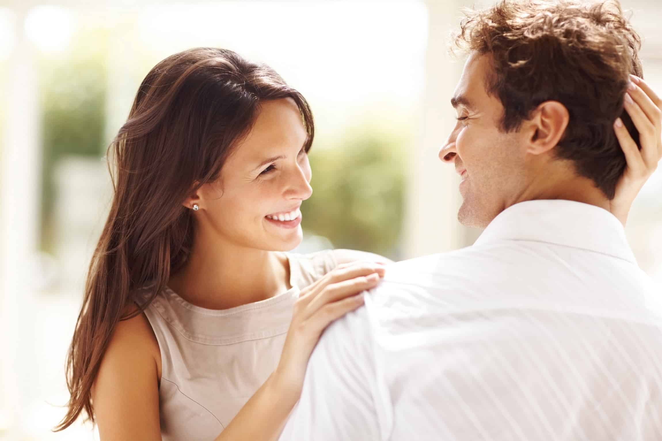 Portrait of affectionate young couple looking at each other while standing together ouydoors