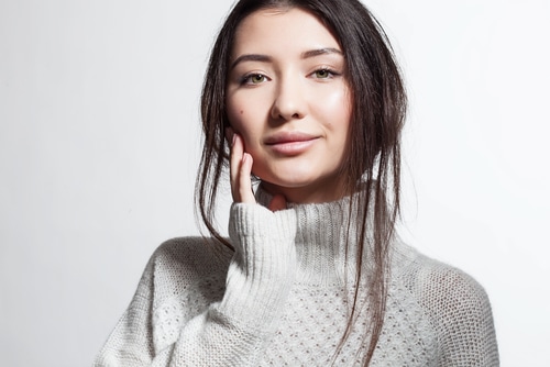 Pretty smiling woman with clean skin in white fluffy sweater