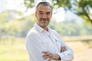 A man smiling and showing the results of a facelift for men over 50