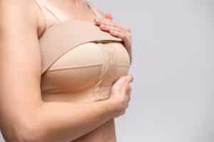 Close up of woman's breasts in compression garment during breast augmentation recovery