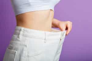 Woman's toned abs and pants too big from weight loss in Salt Lake City, UT