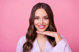 Woman smiling with hand under chin after chin augmentation in Salt Lake City, UT