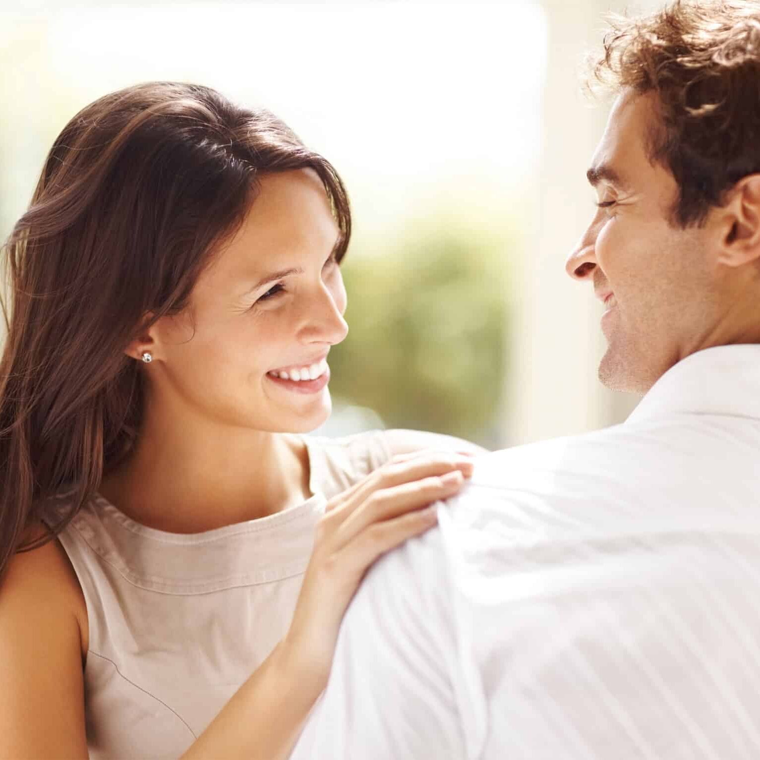 Portrait of affectionate young couple looking at each other while standing together ouydoors